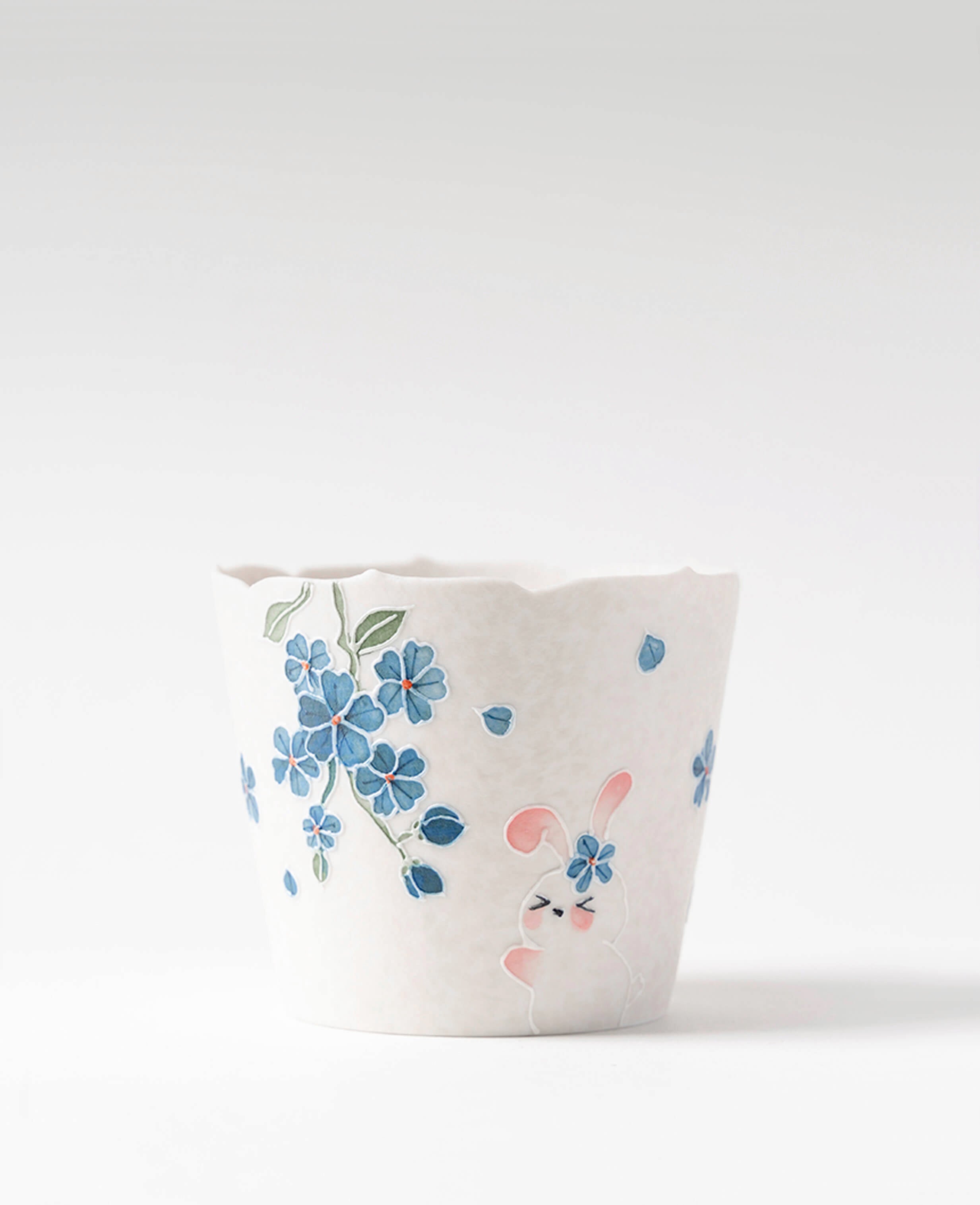 spring reunion ceramic coffee and tea cup from kindred friends collection featuring hand painted bunny and blue floral design front view