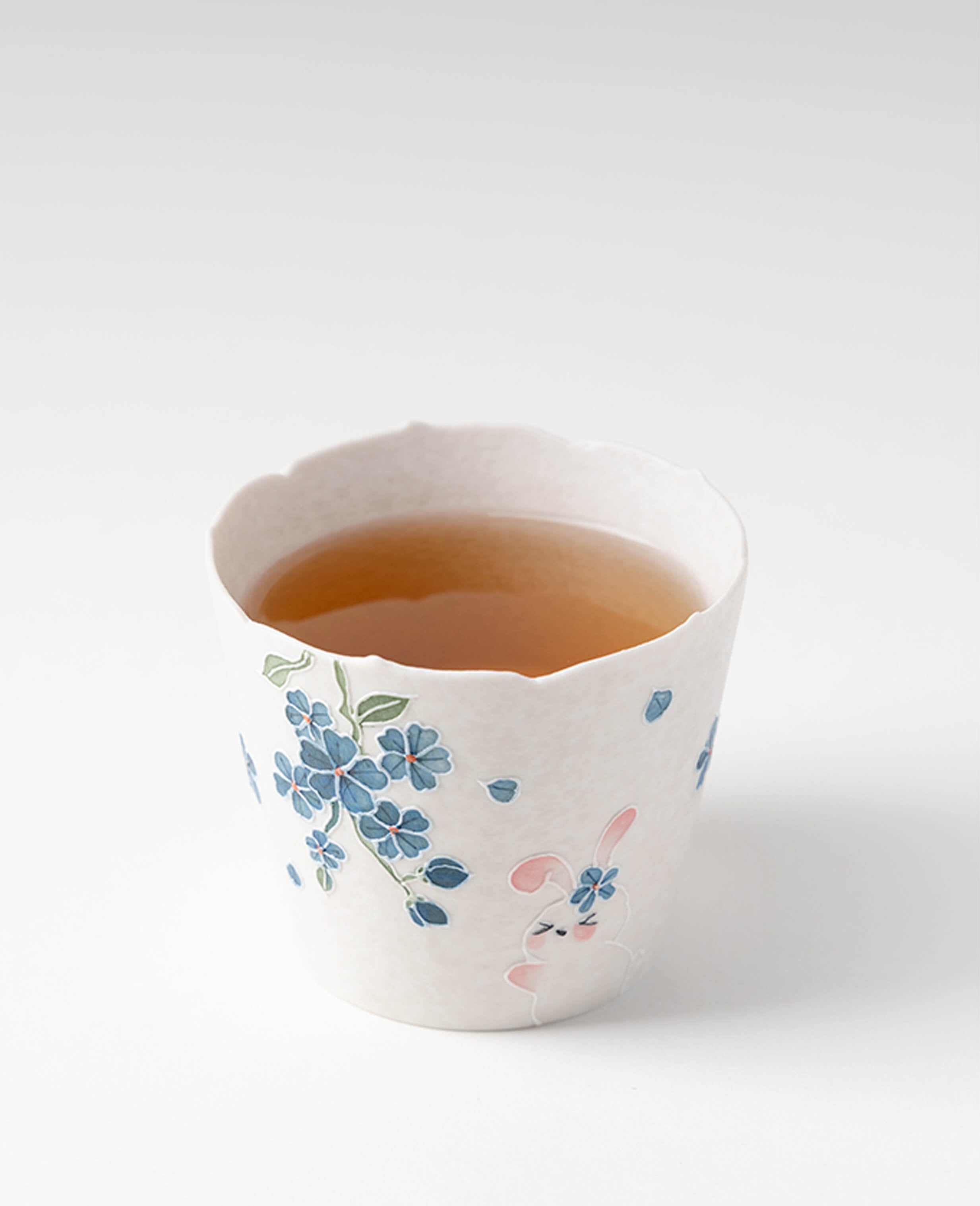 spring reunion handcrafted ceramic coffee and tea cup top view filled with tea showing cute bunny and floral pattern