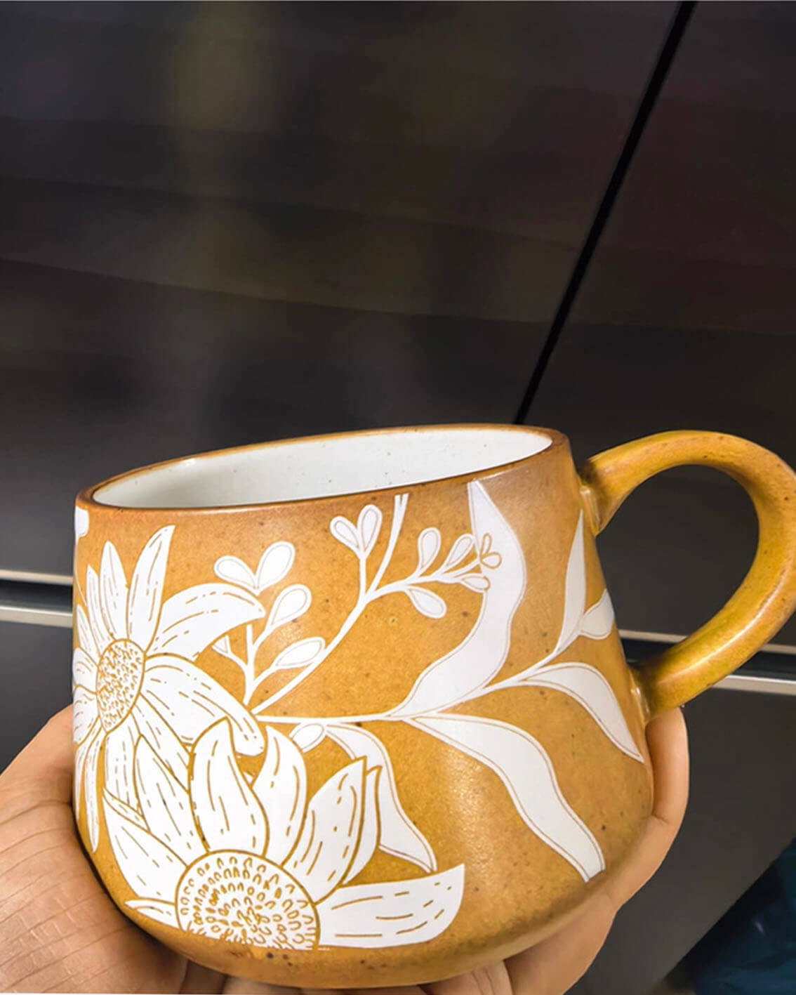 sunday sketch handcrafted coffee and tea mug with white floral pattern gently held in hand from customer testimonial