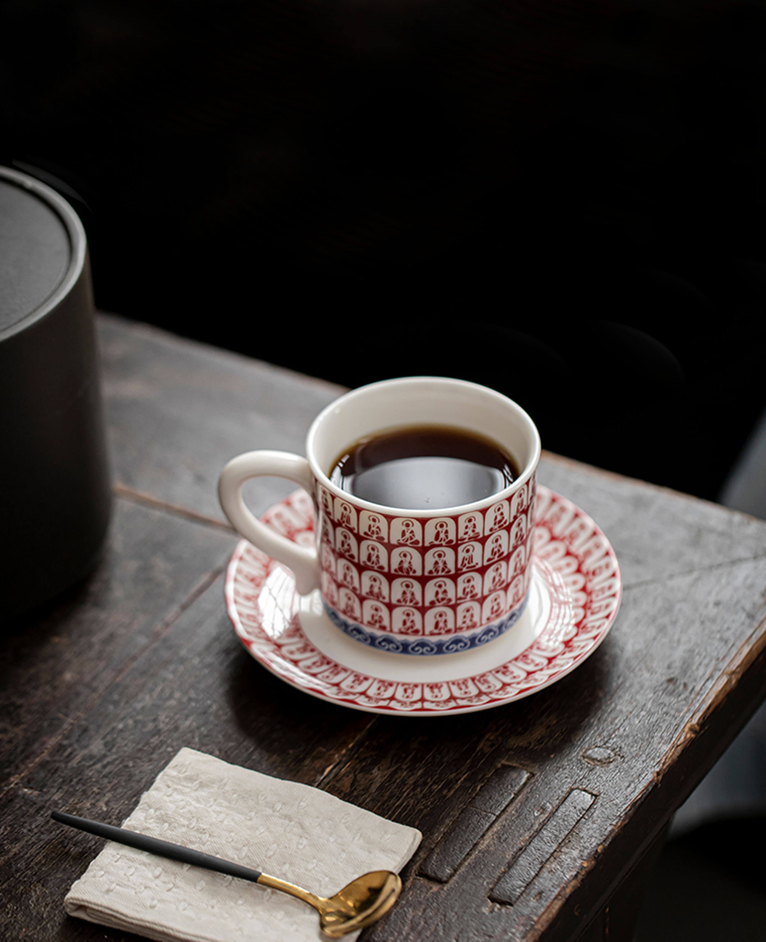 handcrafted thousand buddhas crimson tea cup with saucer on dark vintage wooden table
