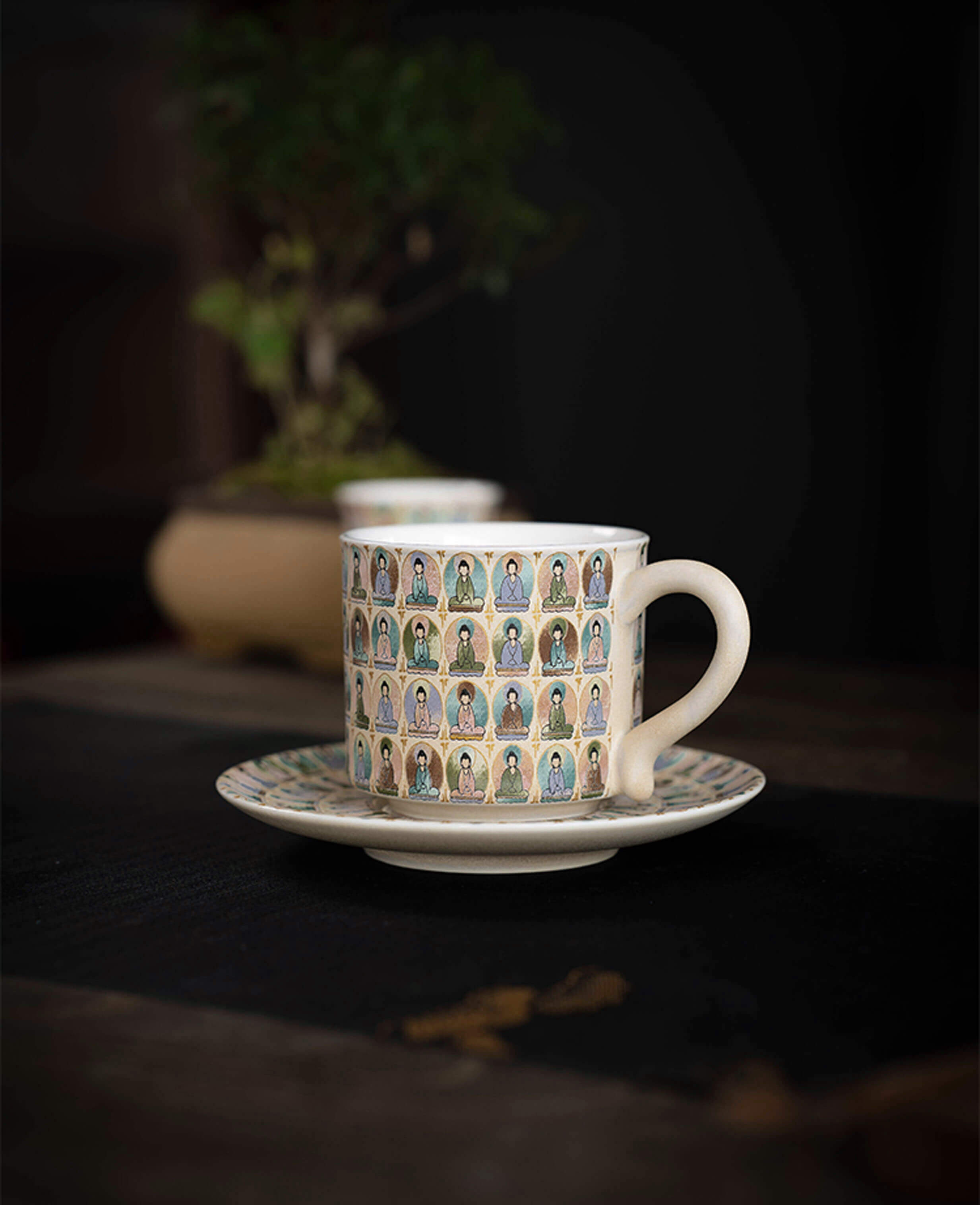 side view of ceramic tea cup and saucer featuring intricate thousand buddhas motif inspired by dunhuang art