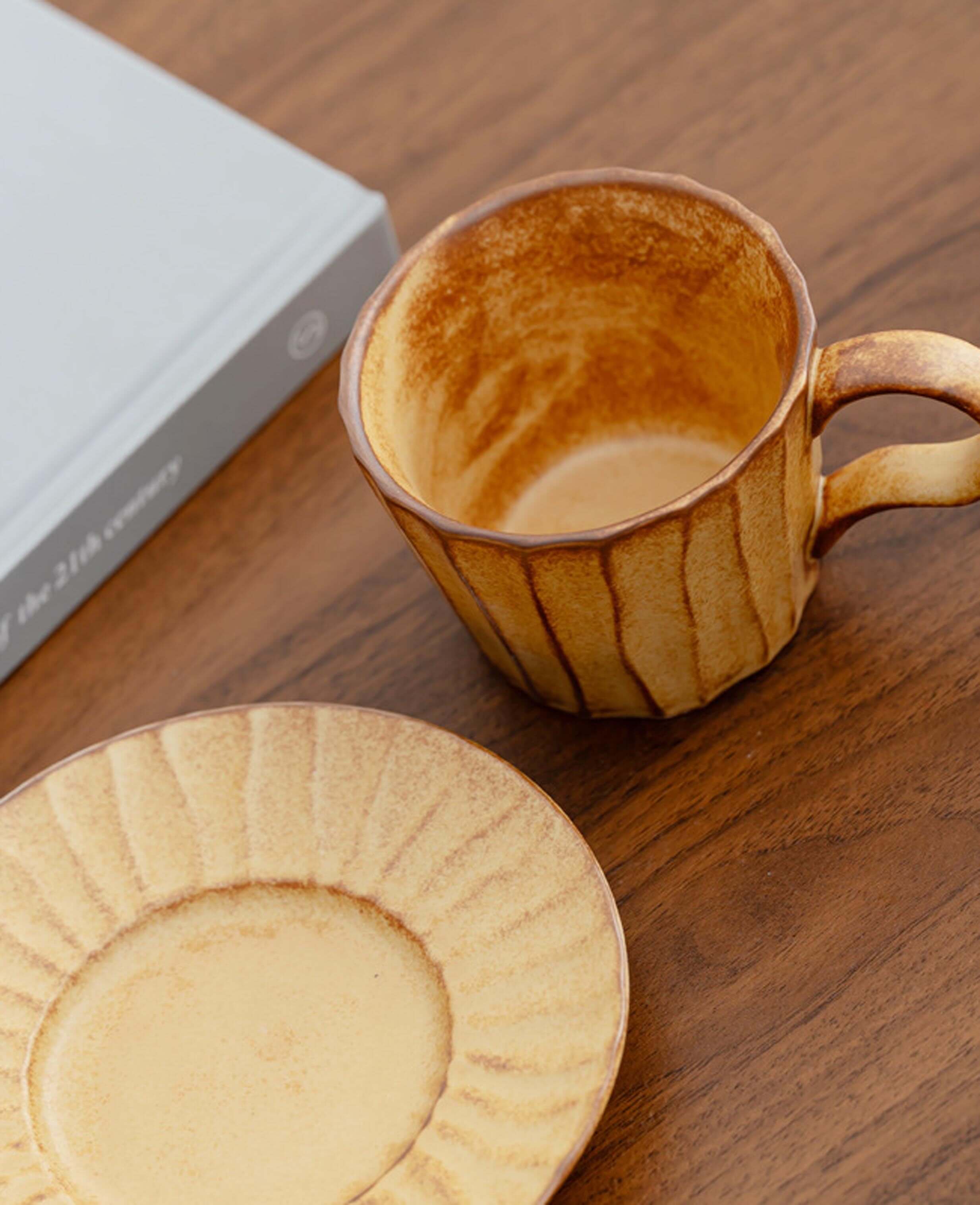 top view of toffee reverie flow ceramic coffee cup and saucer on wooden table