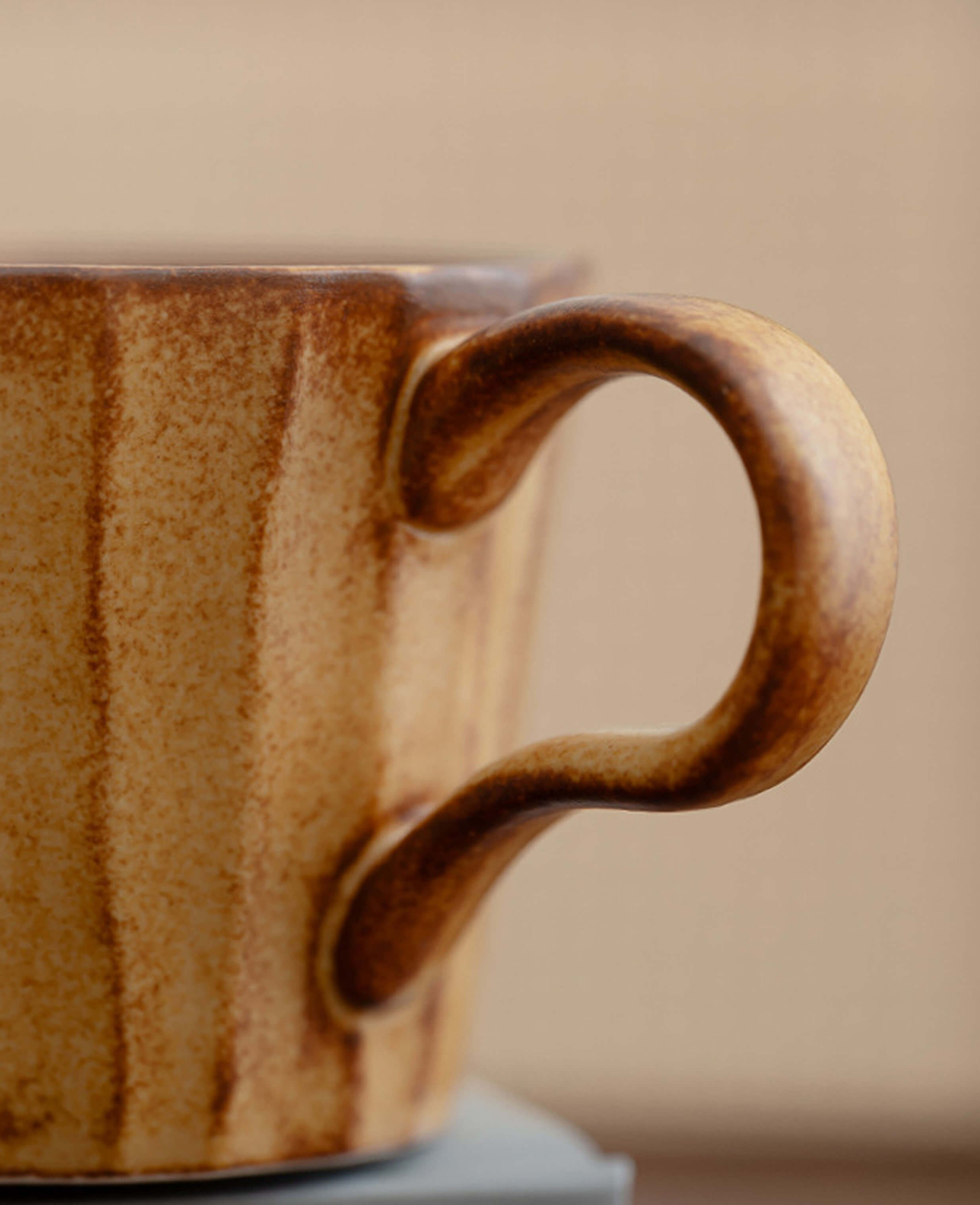 close-up of rustic ceramic handle on toffee reverie flow coffee cup