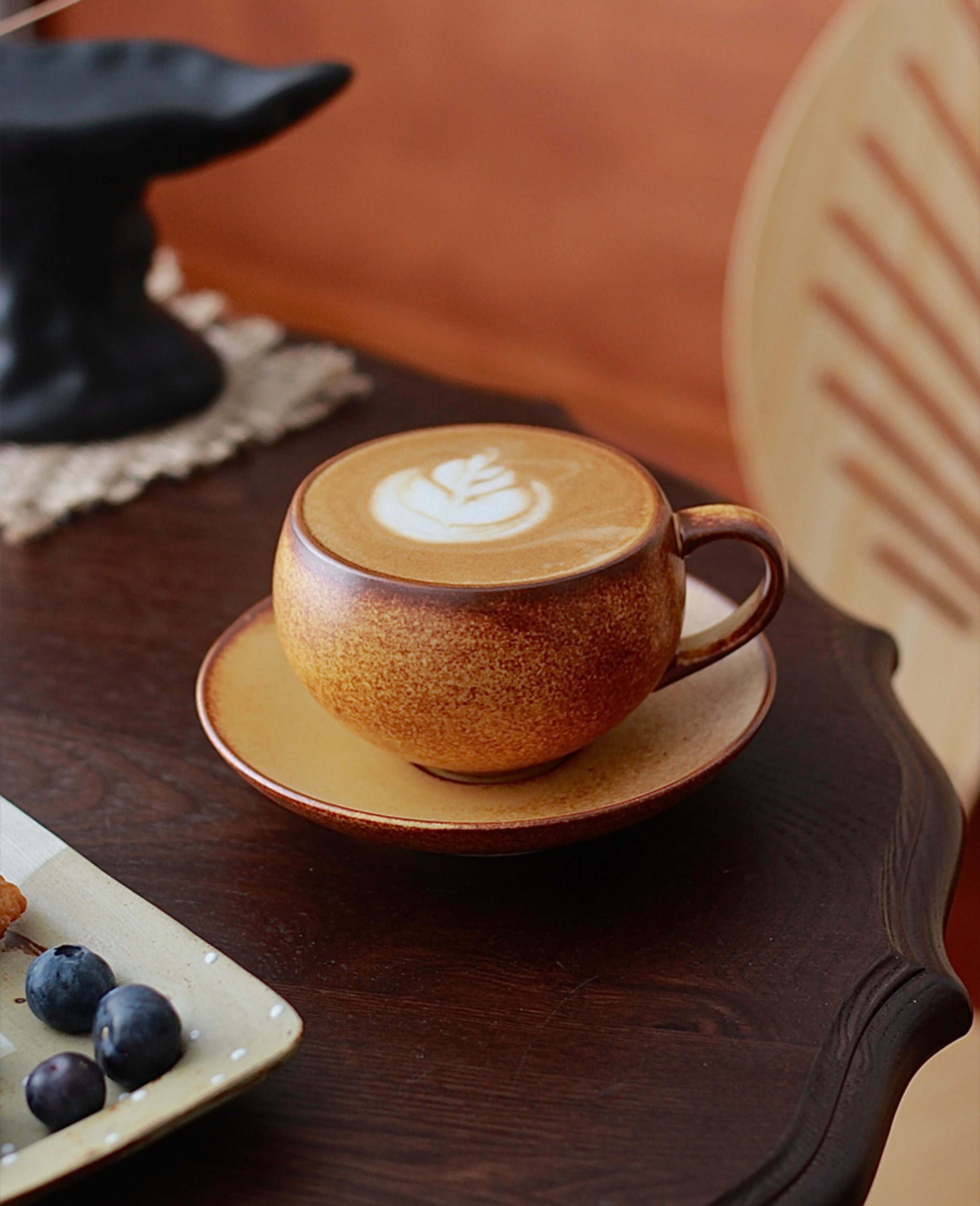 toffee reverie ovolo ceramic cup with latte art on timber table beside fruit