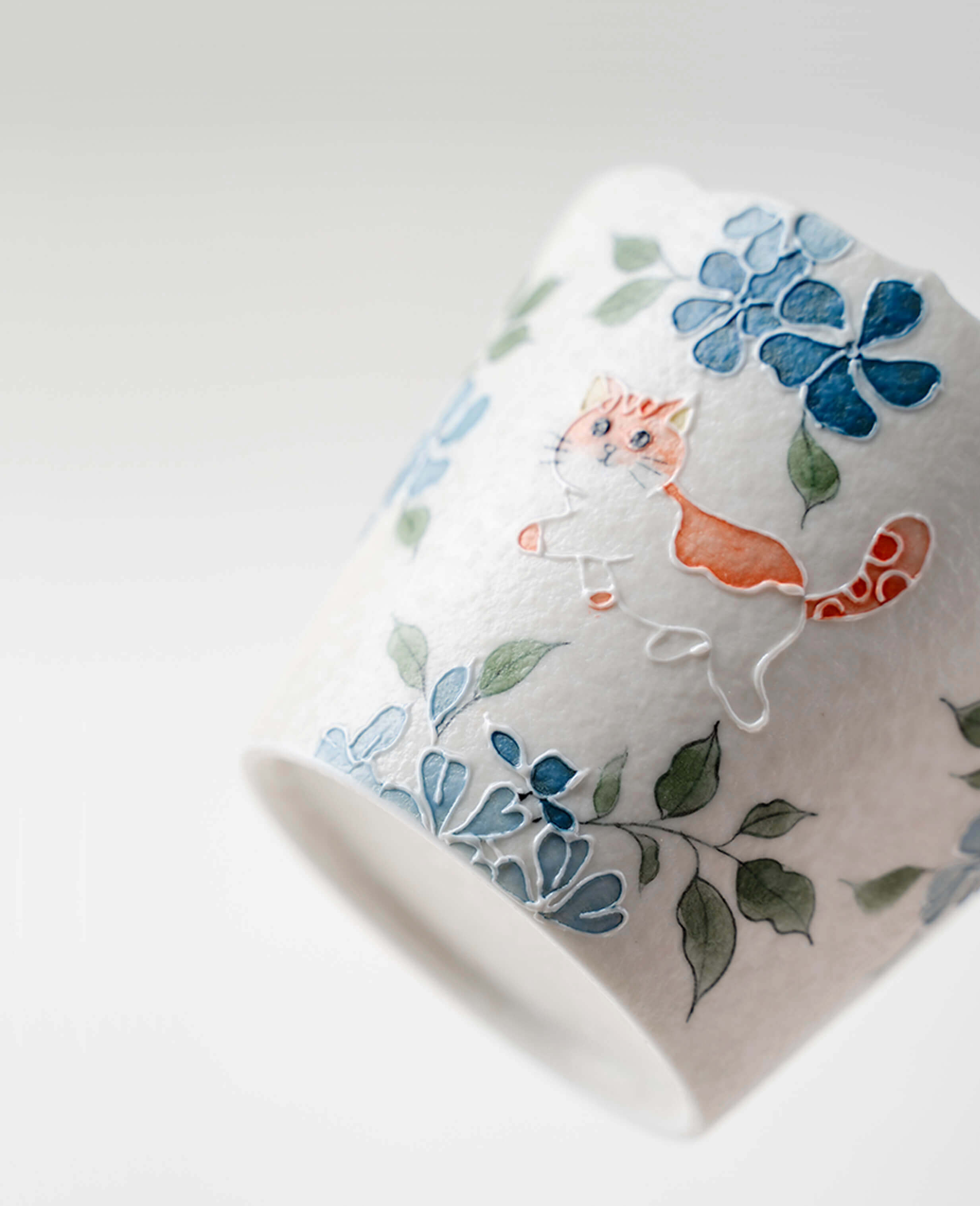 hand painted whisker trail porcelain espresso and coffee cup with orange cat and blue flower details