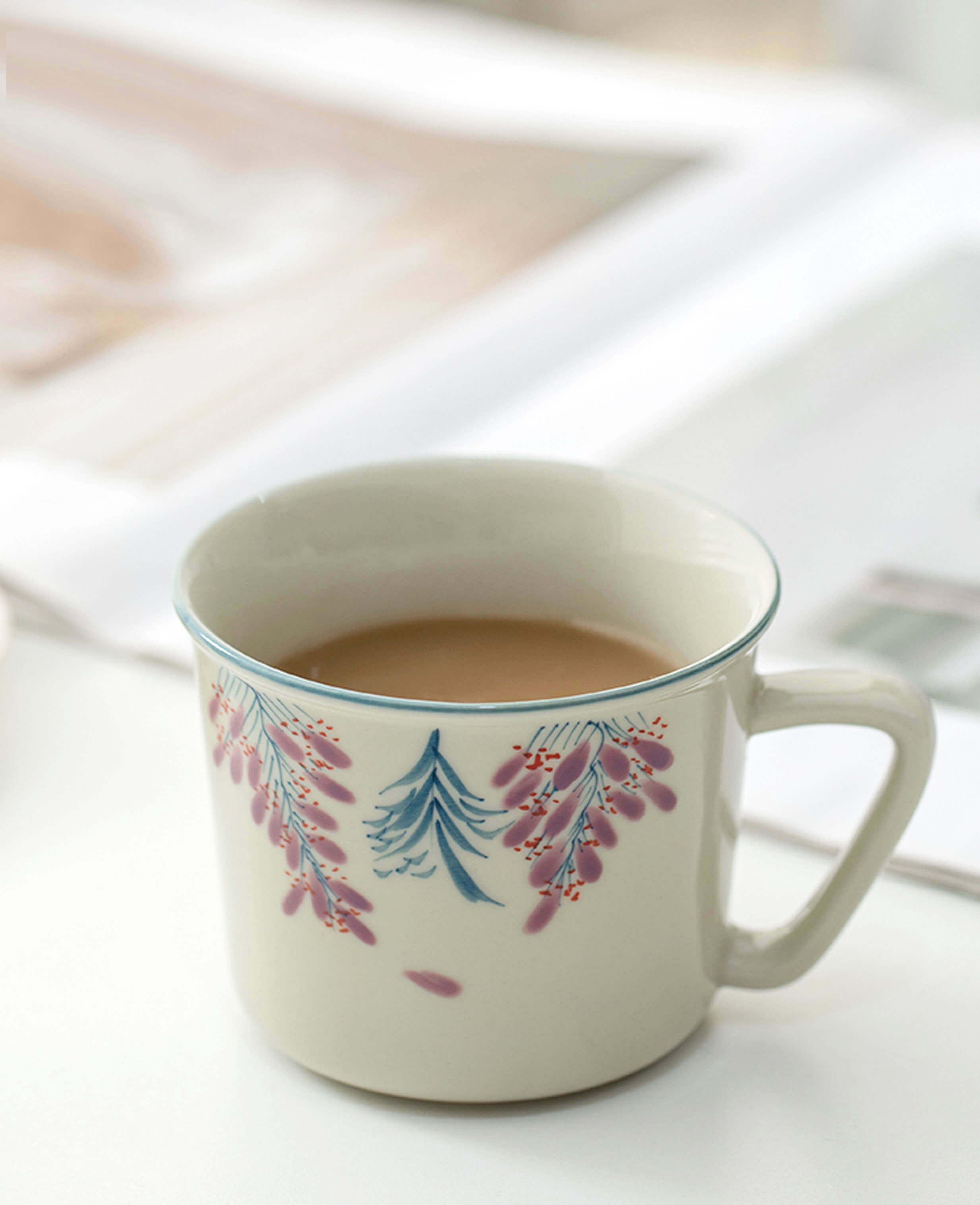 hand painted wisteria trace ceramic coffee cup on bright surface with warm drink inside painted diary collection